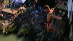 Seorang peserta melakukan terjun bebas dari jembatan Ura e Shejnt dalam kompetisi menyelam tradisional ke-68 di Gjakova, Kosovo, 22 Juli 2018. Kompetisi ini dilakukan dari ketinggian 22 meter. (AP/Visar Kryeziu)