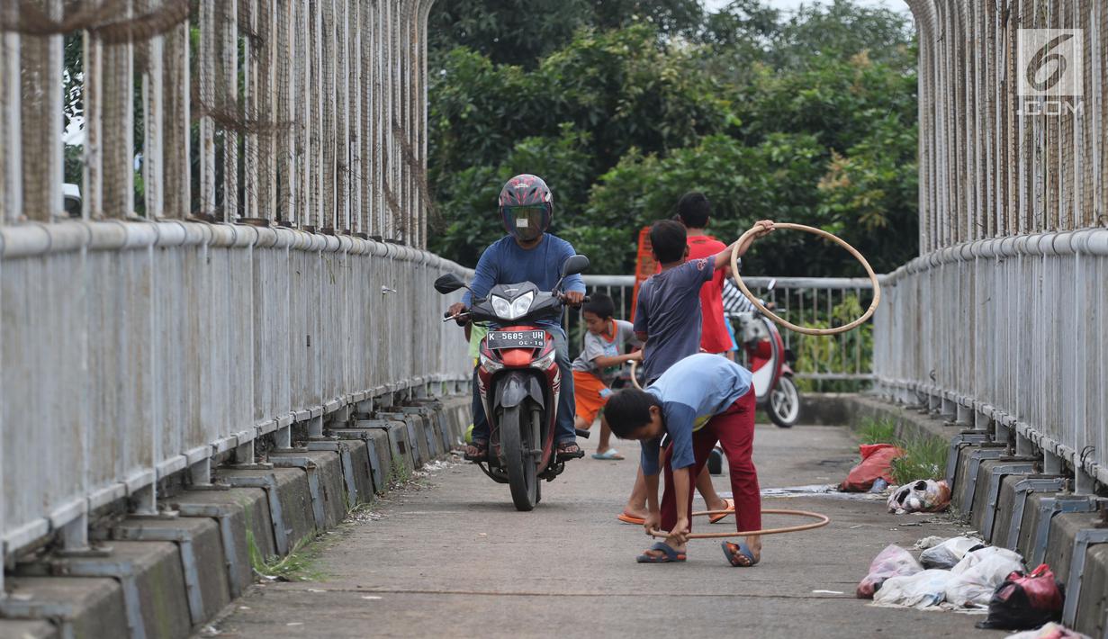 Pengendara motor melintas di samping anak-anak yang bermain di JPO kawasan Cikunir, Bekasi Barat, Senin (12/3). JPO bukan lagi dipenuhi oleh pejalan kaki, tapi berubah fungsi menjadi lahan bermain dan jalan pintas pemotor. (Liputan6.com/Arya Manggala)