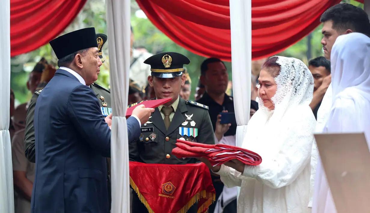 Menteri Pertahanan Sjafrie Sjamsoeddin (kiri) menyerahkan bendera Merah Putih kepada istri Jenderal TNI (Purn) Ryamizard Ryacudu di Taman Makam Pahlawan Nasional, Kalibata, Jakarta, Senin (1/6/2026). (Kapanlagi.com/Budy Santoso)