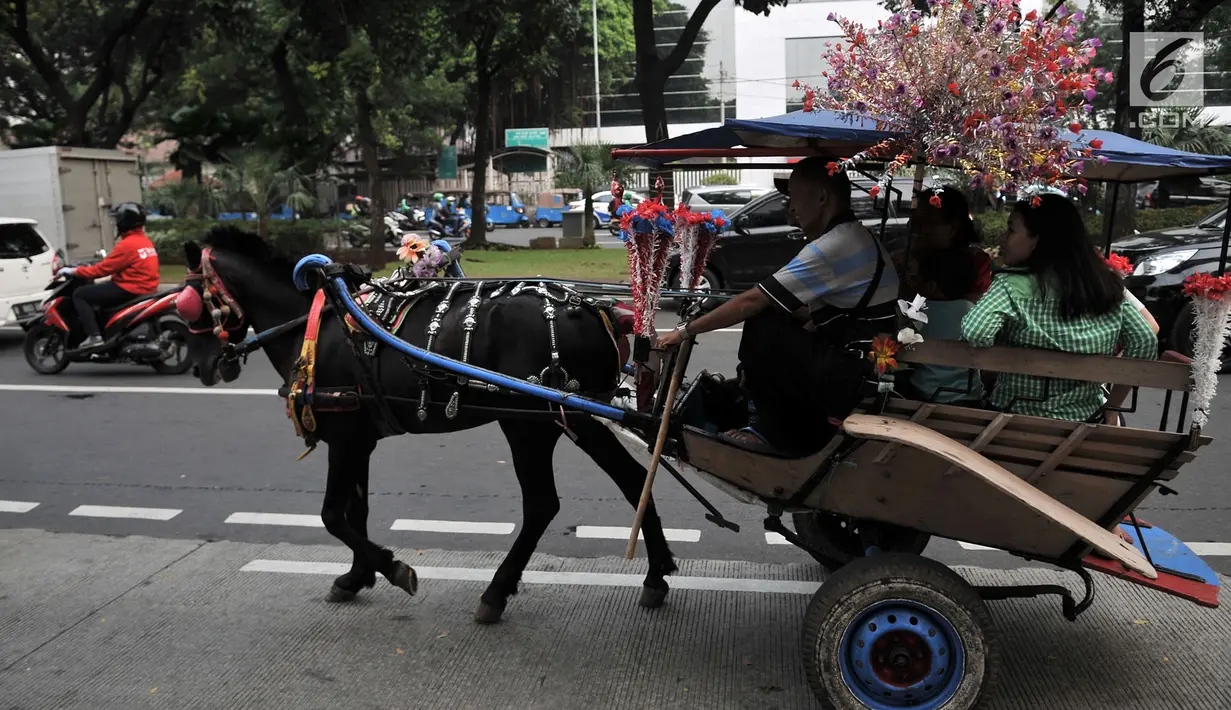 Warga menaiki delman di kawasan Monas, Jakarta, Selasa (3/7). Larangan beroperasi bagi delman di Jakarta Pusat saat Asian Games diberlakukan untuk mengantisipasi penularan virus oleh kuda. (Merdeka.com/Iqbal Nugroho)