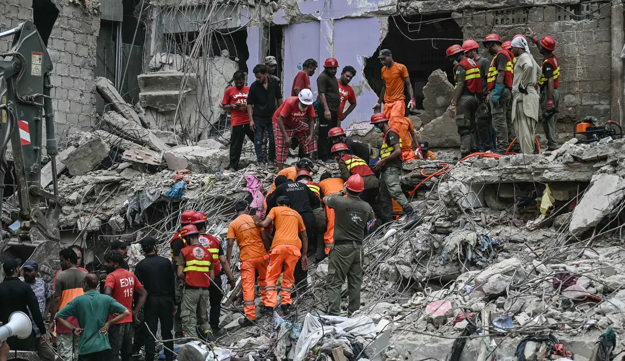 Para petugas penyelamat melakukan operasi pencarian di tengah puing-puing bangunan tempat tinggal yang runtuh di Karachi, Pakistan pada tanggal 5 Juli 2025. (Rizwan TABASSUM/AFP)