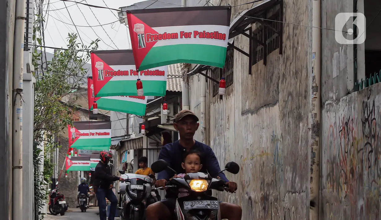 Pengendara sepeda motor melintas di bawah sejumlah bendera Palestina yang terpasang di Palmerah, Jakarta Barat, Sabtu (11/11/2023). (Liputan6.com/Angga Yuniar)