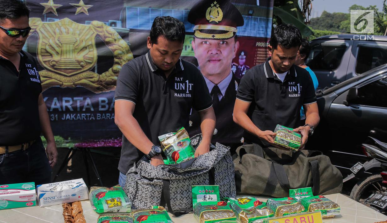 Petugas kepolisian merapikan barang bukti sabu saat rilis kasus narkotika jaringan Internasional Malaysia-Indonesia di Polres Jakarta Barat, Selasa (16/7/2019). Polisi berhasil mengamankan Empat tersangka. (Liputan6.com/Faizal Fanani)