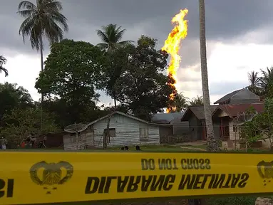 Garis polisi terpasang dekat lokasi kebakaran pengeboran sumur minyak ilegal yang dikelola masyarakat di Peureulak, Provinsi Aceh, Rabu (25/4). Sebanyak 10 orang dilaporkan tewas dan puluhan lainnya luka-luka dalam insiden tersebut. (ILYAS ISMAIL/AFP)