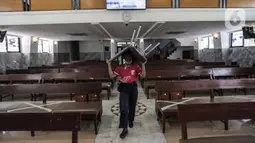 Karyawan memindahkan bangku untuk menyambut kenormalan baru di Gereja Protestan Indonesia Bagian Barat (GPIB) Effatha, Jakarta, Sabtu (4/7/2020). GPIB Effatha menerapkan protokol kesehatan seiring kembali dibukanya gereja tersebut untuk ibadah di tengah pandemi COVID-19. (Liputan6.com/Johan Tallo)