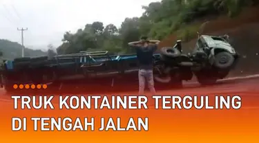 Sebuah truk kontainer terguling di tengah jalan saat menanjak mengundang perhatian.