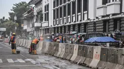 Aktivitas pekerja menyelesaikan proyek revitalisasi fasilitas pejalan kaki atau pedestrian kawasan Kota Tua, Jakarta, Minggu (27/3/2022). Jalur pedestrian itu akan diubah menjadi plaza pedestrian yang lebar sebagai bagian dari penataan kawasan Kota Tua yang rendah emisi (merdeka.com/Iqbal S Nugroho)