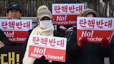 Para pendukung Presiden Korea Selatan yang dimakzulkan, Yoon Suk Yeol, memegang plakat bertuliskan “Tidak Ada Pemakzulan!” di depan Mahkamah Konstitusi di Seoul pada tanggal Selasa 14 Januari 2025. (Jung Yeon-je/AFP)