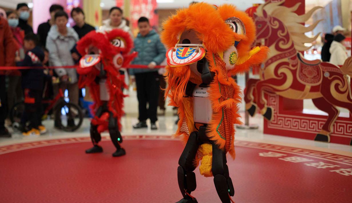 Para pengunjung menyaksikan robot humanoid yang mengenakan kostum tari singa tampil dalam acara pratinjau media sebuah festival kuil robot menjelang Tahun Baru Imlek di Beijing, China, Jumat 13 Februari 2026. (AP Photo/Vincent Thian)