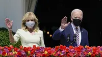 Presiden Joe Biden bersama Ibu Negara Jill Biden melambaikan tangan dari balkon Ruang Biru, Gedung Putih, Washington, Amerika Serikat, Senin (5/4/2021). Gedung Putih kembali meniadakan tradisi Easter Egg Roll menyusul pandemi COVID-19 yang sedang berlangsung. (AP Photo/Evan Vucci)