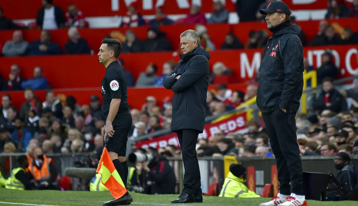 Manajer Manchester United Ole Gunnar Solskjaer (tengah) dan manajer Liverpool Jurgen Klopp (kanan) berdiri di pinggir lapangan pada pertandingan Liga Inggris di Old Trafford, Manchester, Inggris, Minggu (24/10/2021). Liverpool menang 5-0. (AP Photo/Rui Vieira)