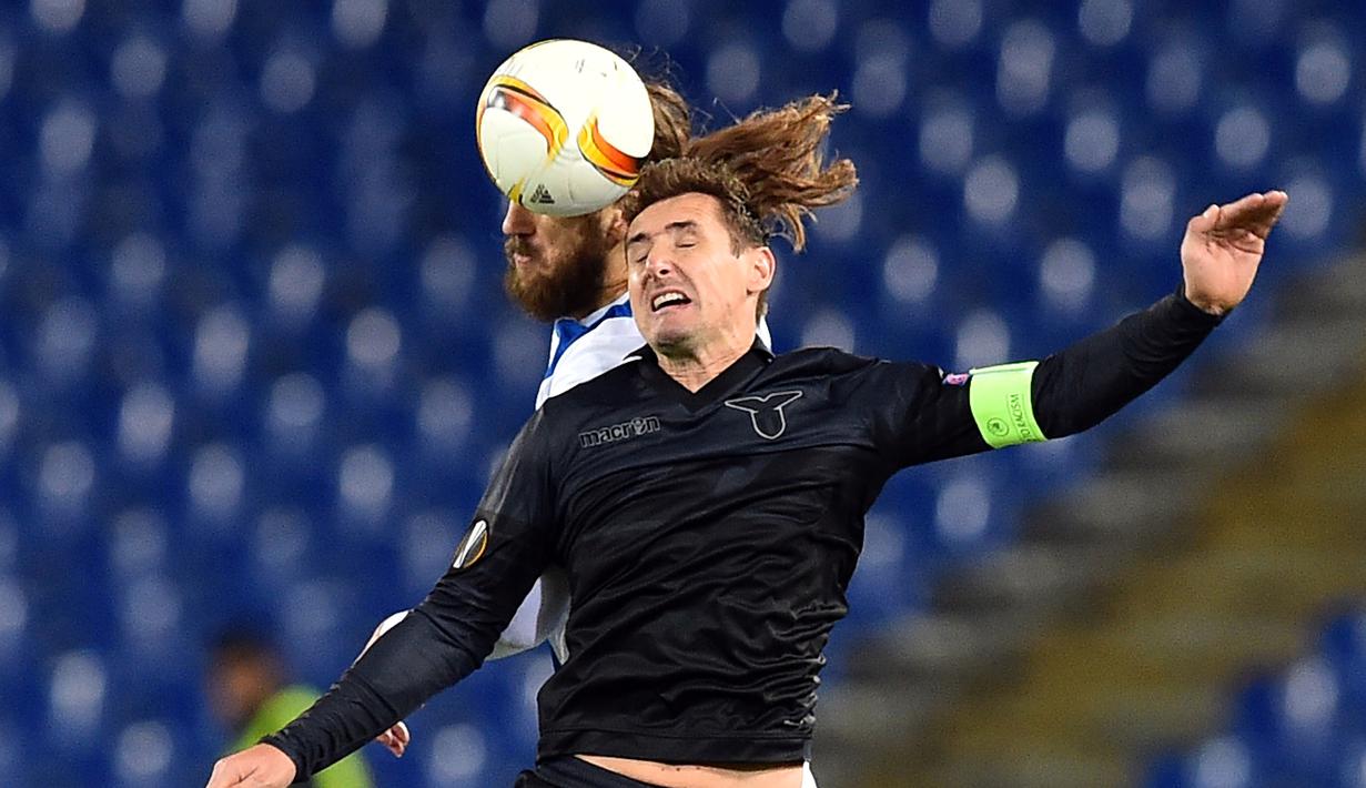 Striker Lazio, Miroslav Klose, berebut bola dengan pemain Dnipropetrovsk, Dmytro Chygrynskiy, dalam lanjutan Grup G Liga Europa yang berlangsung di Stadion Olimpico, Roma, Jumat (27/11/2015) dini hari WIB. (AFP Photo/Gabriel Bouys)
