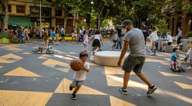 Seorang anak bermain dengan ayahnya di pusat kota Barcelona, Spanyol (25/6/2020). Spanyol telah memasuki tatanan "Normal Baru" pada 21 Juni, dengan mengizinkan kembali warga untuk bebas bepergian di seluruh wilayah negara tersebut. (Xinhua/Balai Kota Barcelona)