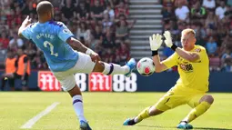 Kiper Bournemouth, Aaron Ramsdale, berusaha menahan bola tendangan Bek Manchester City, Kyle Walker, pada laga Premier League 2019 di Stadion Vitality, Minggu (25/8). Manchester City menang 3-1 atas Bournemouth. (AFP/Glyn Kirk)