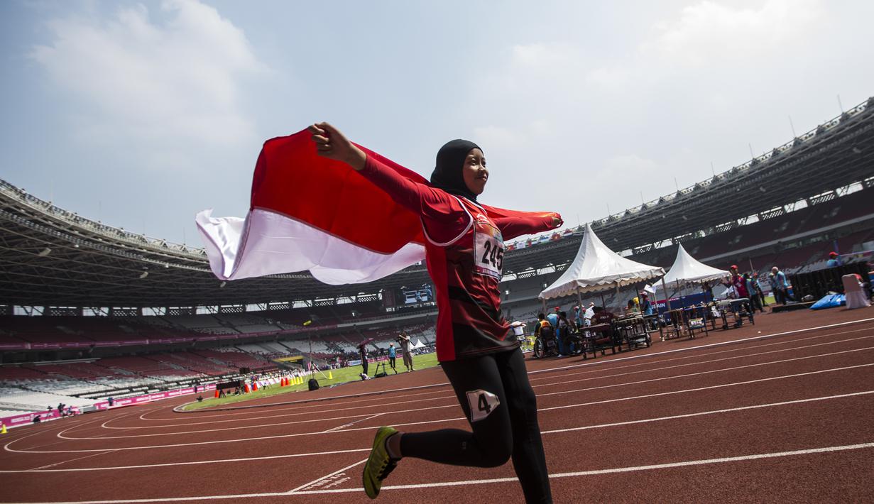 Pelari Indonesia, Tiarani Karisma, melakukan selebrasi usai meraih medali emas Asian Para Games cabang atletik nomor lari 100 meter T42 / T63 di SUGBK, Jakarta, Rabu (10/10/2018). (Bola.com/Vitalis Yogi Trisna)