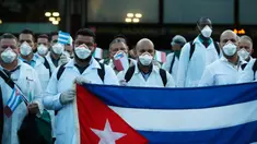 Petugas medis dan paramedis dari Kuba berpose setibanya di bandara Malpensa di Milan, Italia, Minggu (22/3/2020). Sebanyak 53 orang dokter dan perawat menjadi kontingen bantuan medis pertama Kuba untuk membantu mengendalikan pandemi virus Corona di kota kecil Crema, Lombardy. (AP/Antonio Calanni)
