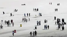 Para turis mengunjungi Tuz Golu atau Danau Tuz yang surut di kota Ankara, Turki, 26 Agustus 2017. Tuz Golu atau Danau Tuz merupakan danau garam terbesar ketiga di dunia yang berada di ketinggian 1.000 meter di atas permukaan laut. (ADEM ALTAN/AFP)