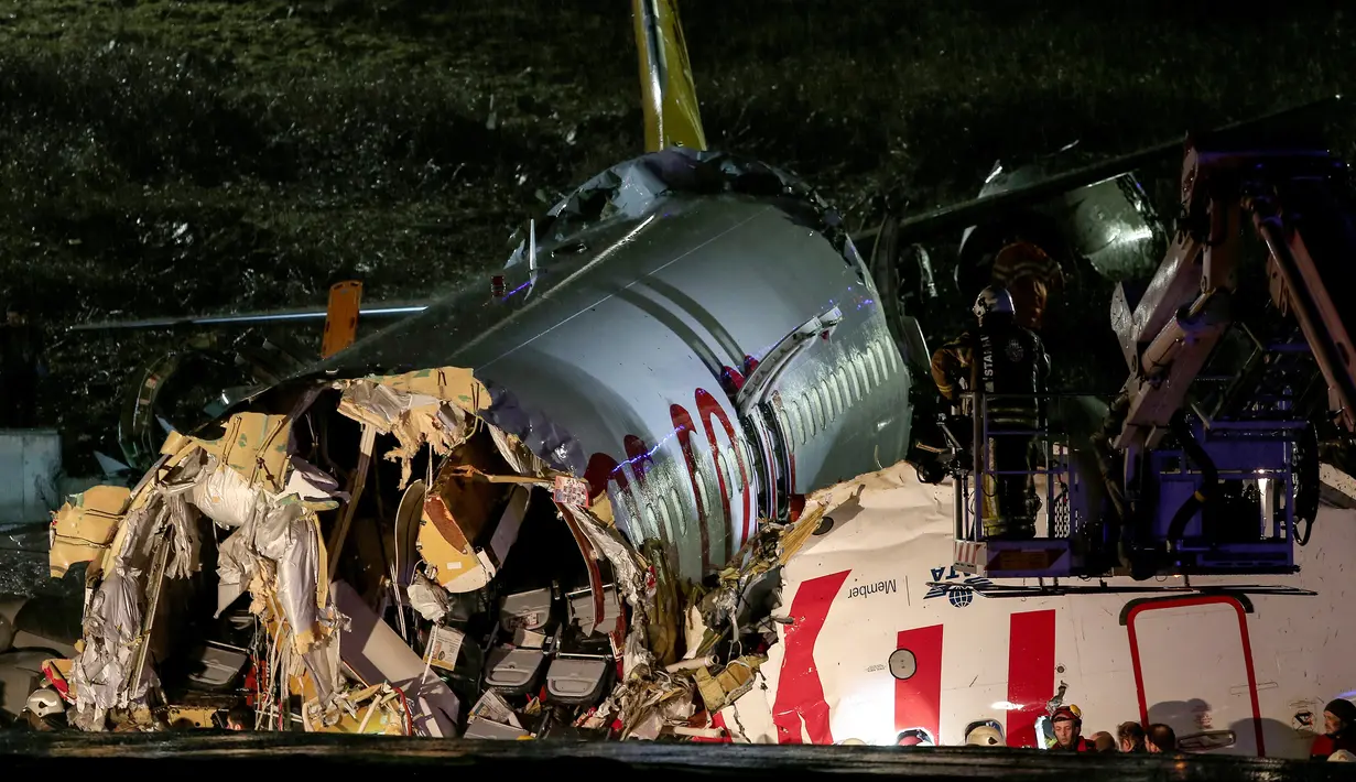 Tim penyelamat dan petugas pemadam kebakaran bekerja setelah sebuah pesawat tergelincir di landasan pacu Bandara Sabiha Gokcen, Istanbul, Turki, Rabu (5/2/2020). Tidak ada korban tewas dalam kejadian ini. (Can Erok/DHA via AP)
