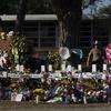 Bunga dan lilin ditempatkan sekitar salib dalam sebuah peringatan di luar Robb Elementary School untuk menghormati para korban yang tewas dalam penembakan sekolah pekan ini di Uvalde, Texas, Amerika Serikat, 28 Mei 2022. (AP Photo/Jae C. Hong)