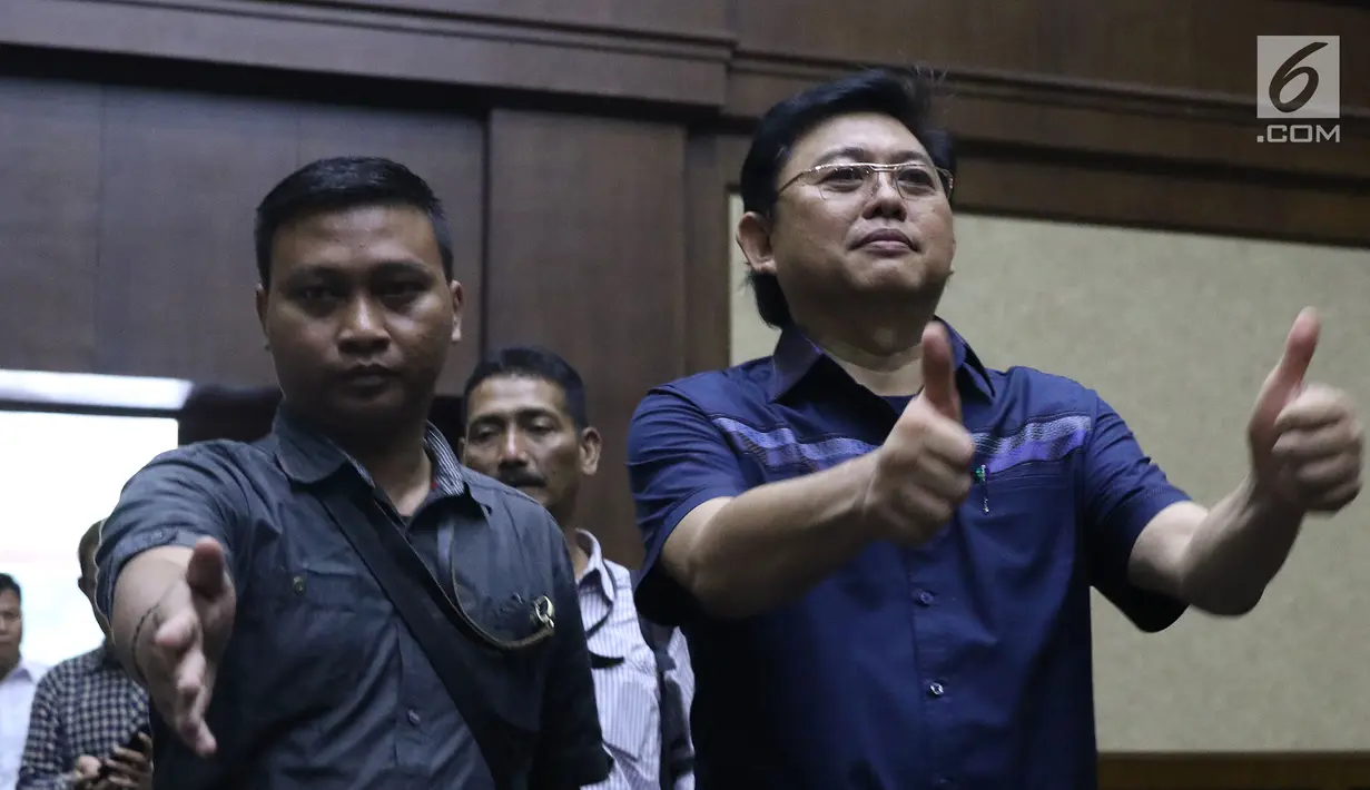 Advokat Lucas (kanan) mengacungkan jempol jelang sidang dakwaan di Pengadilan Tipikor, Jakarta, Rabu (7/11). Lucas didakwa menghalangi proses penyidikan KPK terhadap tersangka mantan petinggi Lippo Group, Eddy Sindoro. (Liputan6.com/Helmi Fithriansyah)