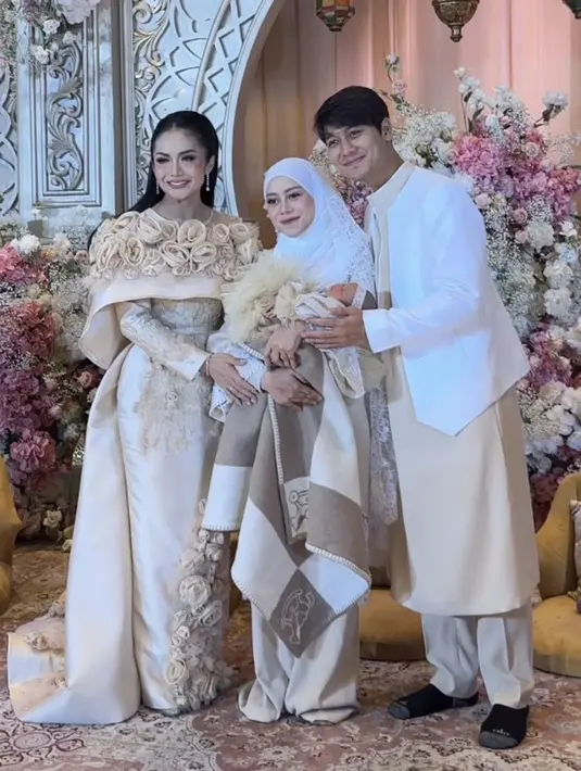 Pada acara akikah ini, Krisdayanti tampil mengenakan long dress body cob warna earth tone dengan hiasan bunga 3D. Gaun pun tampak maksimal dengan train di bagian belakang. [@krisdayantilemos]