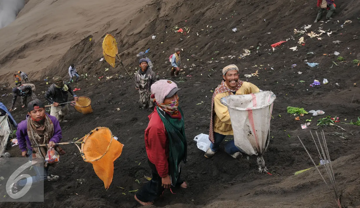Warga bersiap berebut uang dan hasil bumi yang dilemparkan dari bibir kawah Gunung Bromo, Probolinggo, Kamis (21/7). Warga Tengger melakukan ritual lempar hasil bumi sebagai wujud syukur pada Sang Hyang Widi. (Liputan6.com/Helmi Fithriansyah)