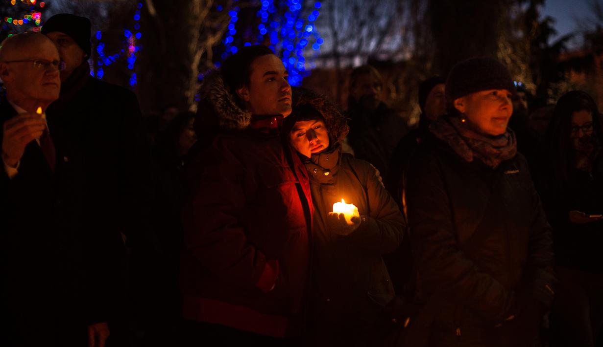 Sejumlah orang mengheningkan cinta dalam aksi dukungan pada komunitas muslim di Moncton, New Brunswick, Senin (30/1). Dukungan itu setelah aksi penembakan di sebuah masjid di Kota Quebec, Kanada. (Darren Calabrese/The Canadian Press via AP)