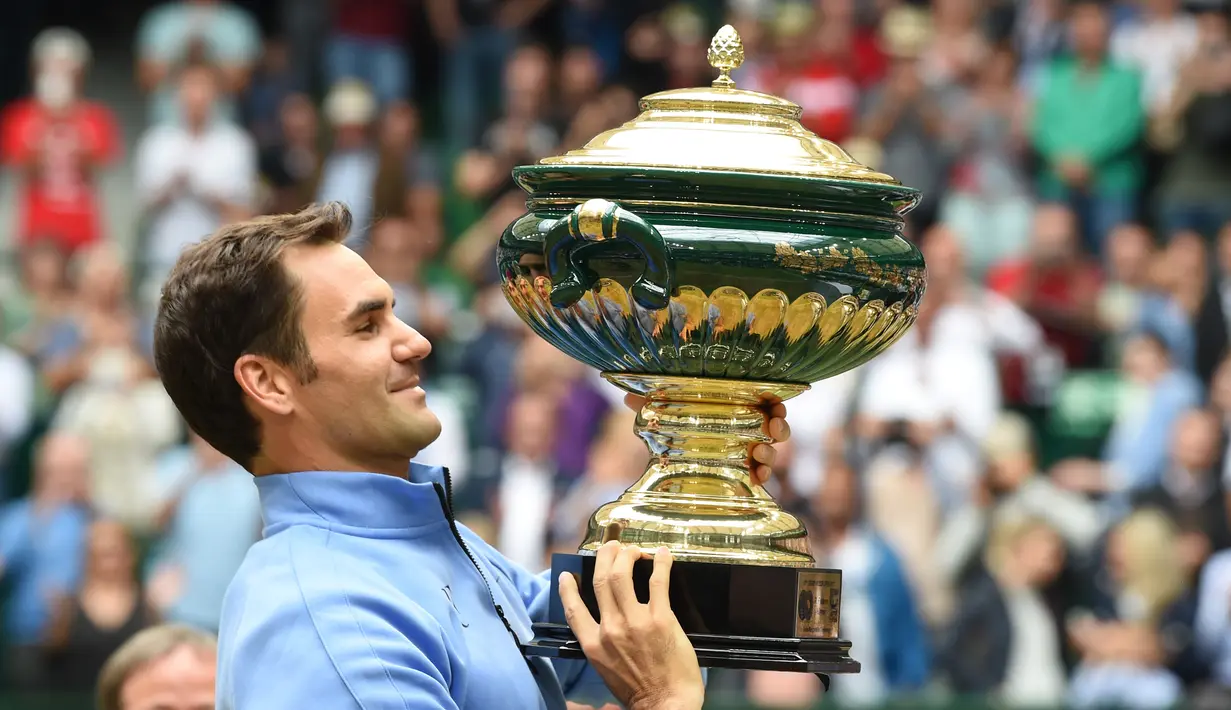 Roger Federer mengangkat trofi juara ATP Tour Jerman usai mengalahkan petenis Jerman, Alexander Zverev 6-1, 6-3 di Gerry Weber Open tennis tournament, Halle, Jerman, (25/6/2017), (AFP/Carmen Jaspersen)