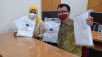 Peserta menerima paket kain yang akan dijahit menjadi Alat Pelindung Diri (APD) dalam pelatihan pembuatan APD di Yogyakarta yang diselenggarakan oleh CISDI. Foto: CISDI.