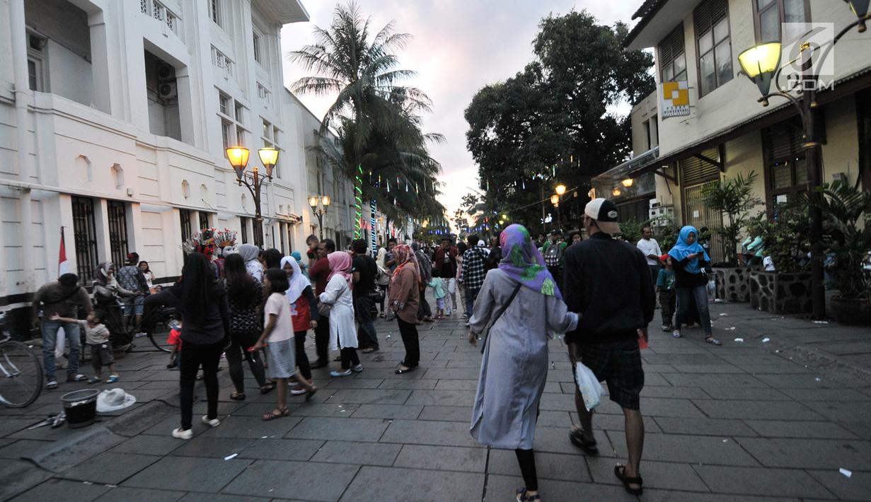 Sejumlah pengunjung memadati kawasan wisata Kota Tua, Jakarta, Selasa (27/6). Pengunjung bisa menikmati Kota Tua, dari menyewa sepeda ontel dengan berbagai warna sampai berfoto bersama dengan manusia patung. (Liputan6.com/Yoppy Renato)
