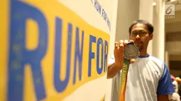 Pelari Jelajah Timur, Candra Nugraha menunjukkan medali dalam acara media briefing di Jakarta, Senin (30/9/2019). Jelajah Timur - Run for Equality adalah charity run untuk membantu pengadaan akses air bersih dan mendorong kesetaraan anak perempuan di Nusa Tenggara Timur. (Liputan6.com/Fery Pradolo)