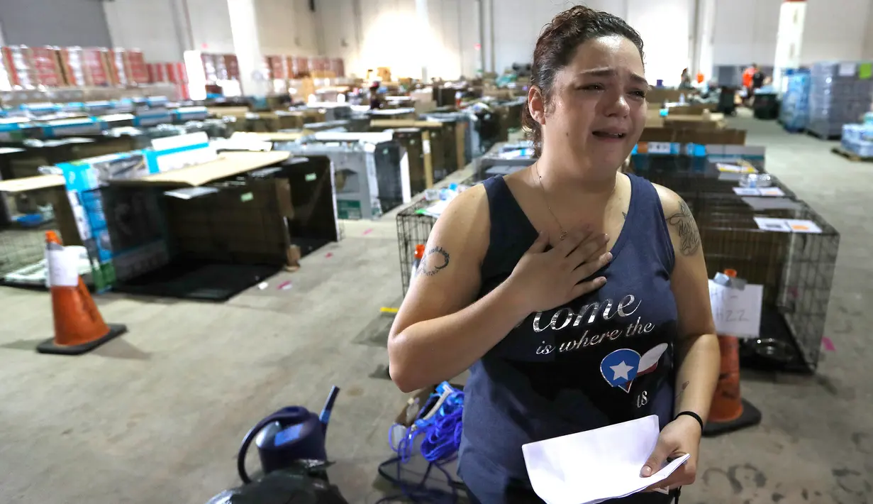 Kyri Andell menangis saat melihat dua anjingnya yang hilang di Paviliun Pet Reunion di NRG Arena di Houston (13/9). Hewan-hewan tersebut akan tinggal selama 30 hari sebelum naik adopsi. (Karen Warren/Houston Chronicle via AP)