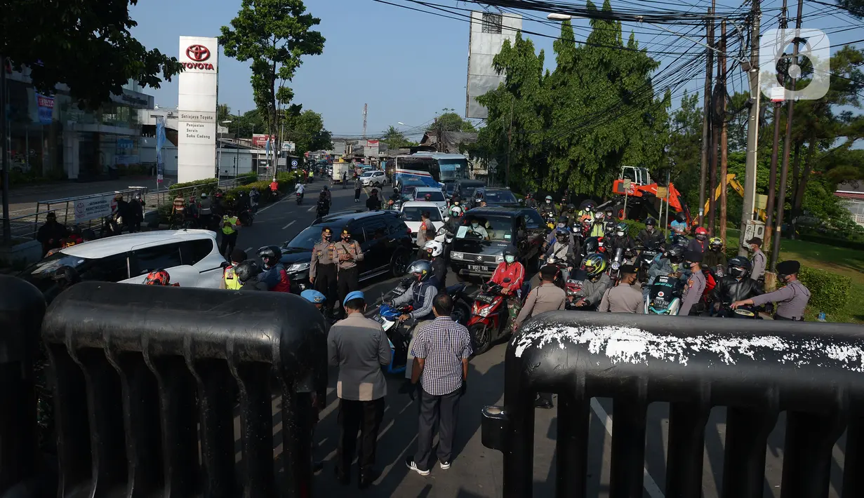 Aparat kepolisian berjaga di pos penyekatan di Jalan Raya Bogor, Jakarta Timur, Selasa (6/7/2021). Petugas Gabungan Polri dan TNI menyiapkan kendaraan taktis untuk membantu penyekatan selama PPKM Darurat Jawa - Bali. (merdeka.com/Imam Buhori)