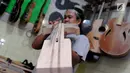 Pengrajin mengecek tingkat akurasi saat membuat gitar di Syukey Guitars, Cirendeu, Ciputat Timur (3/4). Gitar buatan tangan ini dipatok dengan harga Rp 5 juta hingga Rp 20 juta. (Merdeka.com/Arie Basuki)