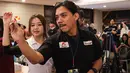Dartslive Support Player asal Singapura Hedy Wong mengajarkan salah satu jurnalis yang mencoba alat di acara peluncuran Darts Station di lantai F7 FX Sudirman, Senayan, Jakarta pada Sabtu (15/11/2025). (Bola.com/Abdul Aziz)