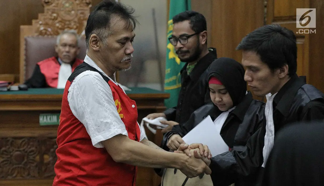 Terdakwa kasus penyalagunaan narkoba, Tio Pakusadewo memeluk kuasa hukumnya saat sidang lanjutan di PN Jakarta Selatan, Kamis (12/7). Sidang beragendakan pembacaan duplik atas replik dari JPU pekan lalu. (Liputan6.com/Faizal Fanani)