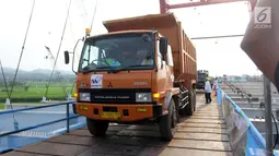 Suasana saat Menteri PUPR Basuki Hadimuljono menaiki truk untuk melintasi Jembatan Kali Kuto di Batang, Jateng, Rabu (13/6). Menurut Hadi, pengoperasian sementara jembatan ini untuk mengurai kepadatan kendaraan pemudik. (Liputan6.com/Arya Manggala)