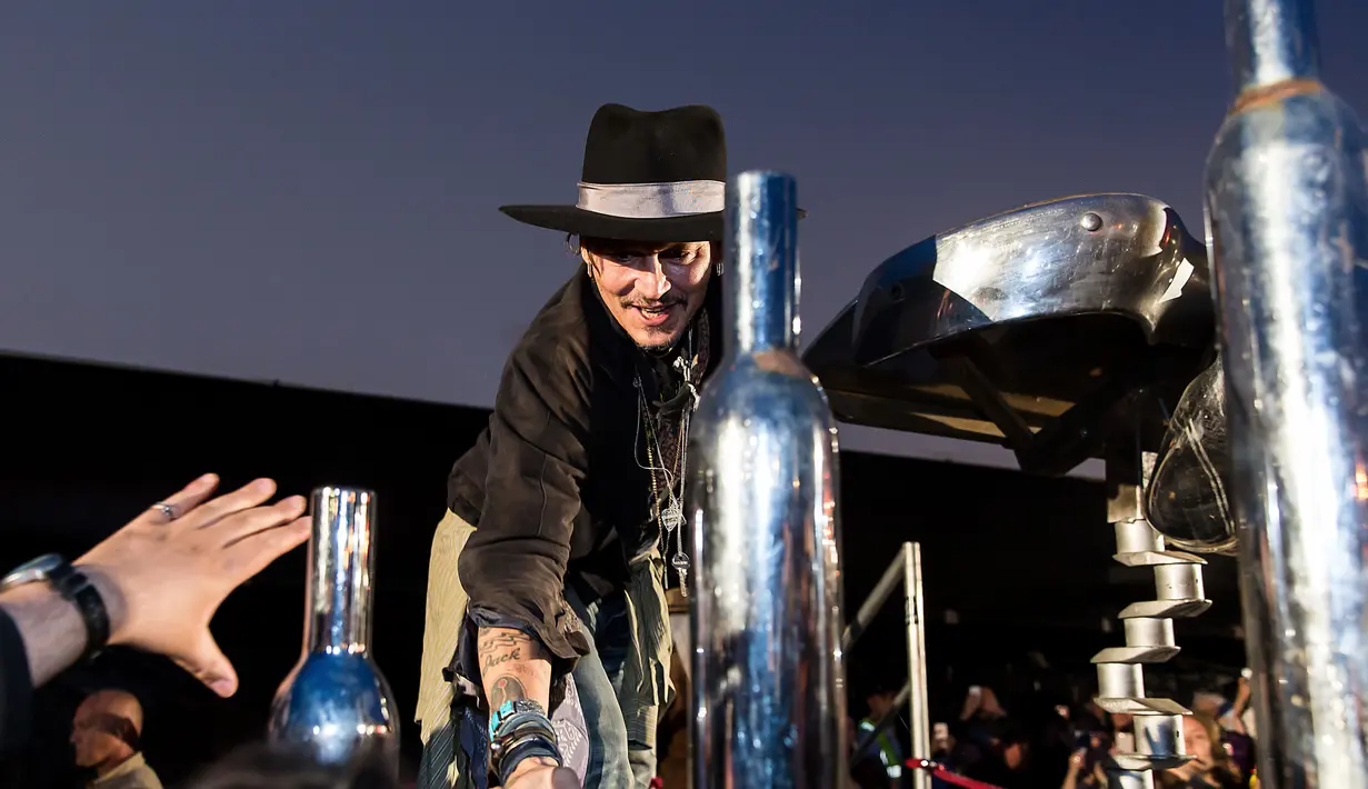 Johnny Depp menyapa penggemarnya sebelum mempresentasikan film terbarunya berjudul The Libertine, di Cinemageddon, Worthy Farm, Somerset selama Festival Glastonbury di Inggris, (22/6). (Photo by Grant Pollard/Invision/AP)