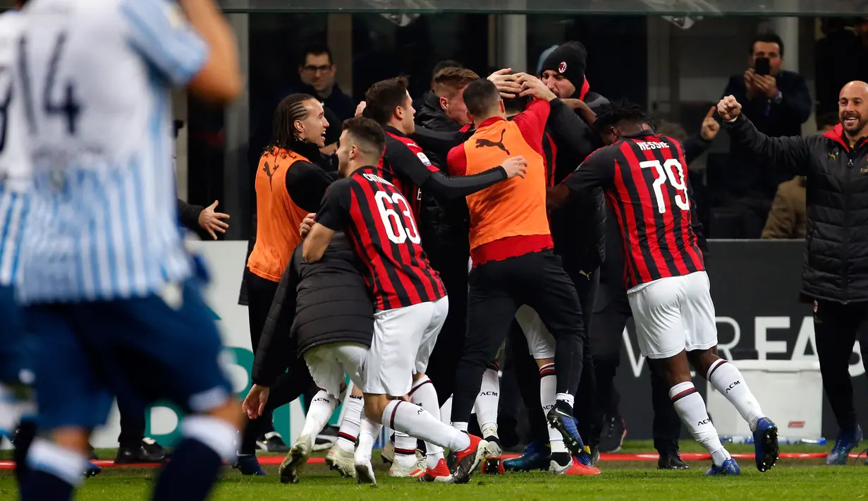 Para pemain AC Milan memeluk Gonzalo Higuain setelah mencetak gol selama pertandingan melawan SPAL pada lanjutan Liga Serie A Italia di stadion San Siro (29/12). Milan menang tipis atas SPAL 2-1. (AP Photo/Antonio Calanni)