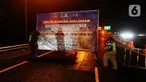 Petugas Tol Jasa Marga memasang papan penutupan jalur Puncak di pintu keluar tol Gadog, Bogor, Jawa Barat, Minggu (31/12/2023). (merdeka.com/Arie Basuki)