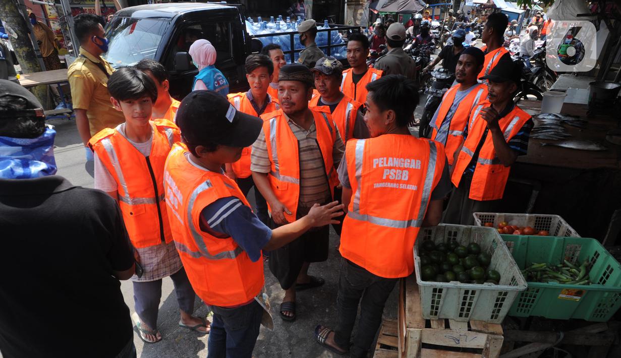 Pelanggar PSBB mengenakan rompi khusus saat razia masker di Pasar Reni, Pamulang, Tangerang Selatan, Banten, Selasa (1/9/2020). Razia terhadap pedagang dan pengunjung pasar ini juga dilakukan rapid test guna mencegah penularan COVID-19. (merdeka.com/Arie Basuki)