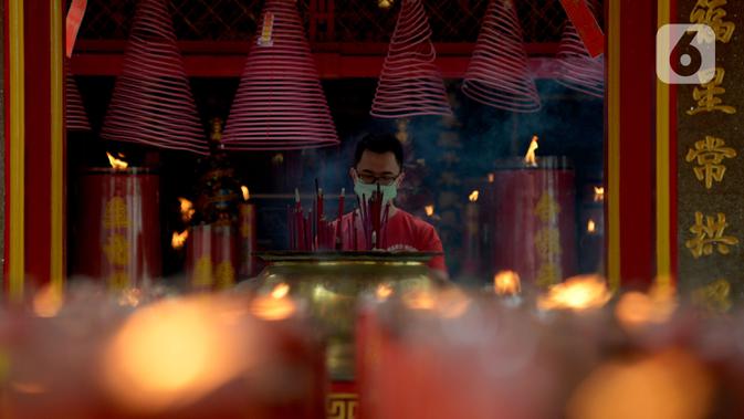 Warga keturunan Tionghoa melakukan sembahyang saat perayaan Tahun Baru Imlek 2572 di Vihara Dharma Bhakti, Glodok, Jakarta, Jumat (12/2/2021). Perayaan Imlek tahun ini, pengurus vihara melakukan pembatasan pengunjung dan tetap mengikuti protokol kesehatan COVID-19. (merdeka.com/Imam Buhori)