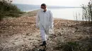 Seorang ahli memeriksa kematian ikan di tepi Danau Koroneia, Yunani, Kamis (19/9/2019). Danau Koroneia telah menyusut menjadi sekitar sepertiga dari ukuran aslinya selama tiga dekade terakhir. (AP Photo/Giannis Papanikos)