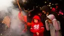 Anak-anak ketakutan melihat peserta berkostum iblis dalam Festival Correfoc di Palma de Mallorca, Spanyol, Minggu (21/1). Festival ini biasanya diadakan pada malam hari dan bertempat di alun-alun kota yang dihias menyerupai neraka. (AFP PHOTO/JAIME REINA)