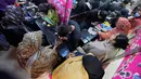 Wanita dan anak-anak akan mengunjungi pasar yang buka hingga larut malam untuk mengantre di stan seniman henna. Tampak dalam foto, para ahli kecantikan, di bagian atas, melukis 'Henna' tradisional di tangan pelanggan untuk perayaan Idul Fitri, yang menandai berakhirnya bulan suci Ramadan, di Rawalpindi, Pakistan, Rabu, 18 Maret 2026. (AP Photo/Anjum Naveed)