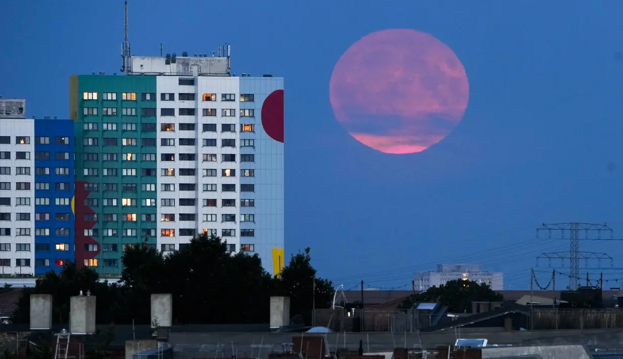 Bulan purnama terbesar atau supermoon muncul dari belakang sebuah bangunan tempat tinggal di Berlin, Senin, 19 Agustus 2024. (AP Photo/Markus Schreiber)