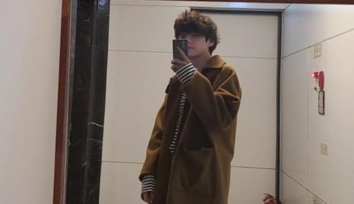Kaus garis hitam putih yang dipadukan dengan coat berwarna coklat ini juga bisa dijadikan inspirasi. Gaya OOTD V BTS ini pun banjir pujian dari netizen. (Liputan6.com/IG/@thv)
