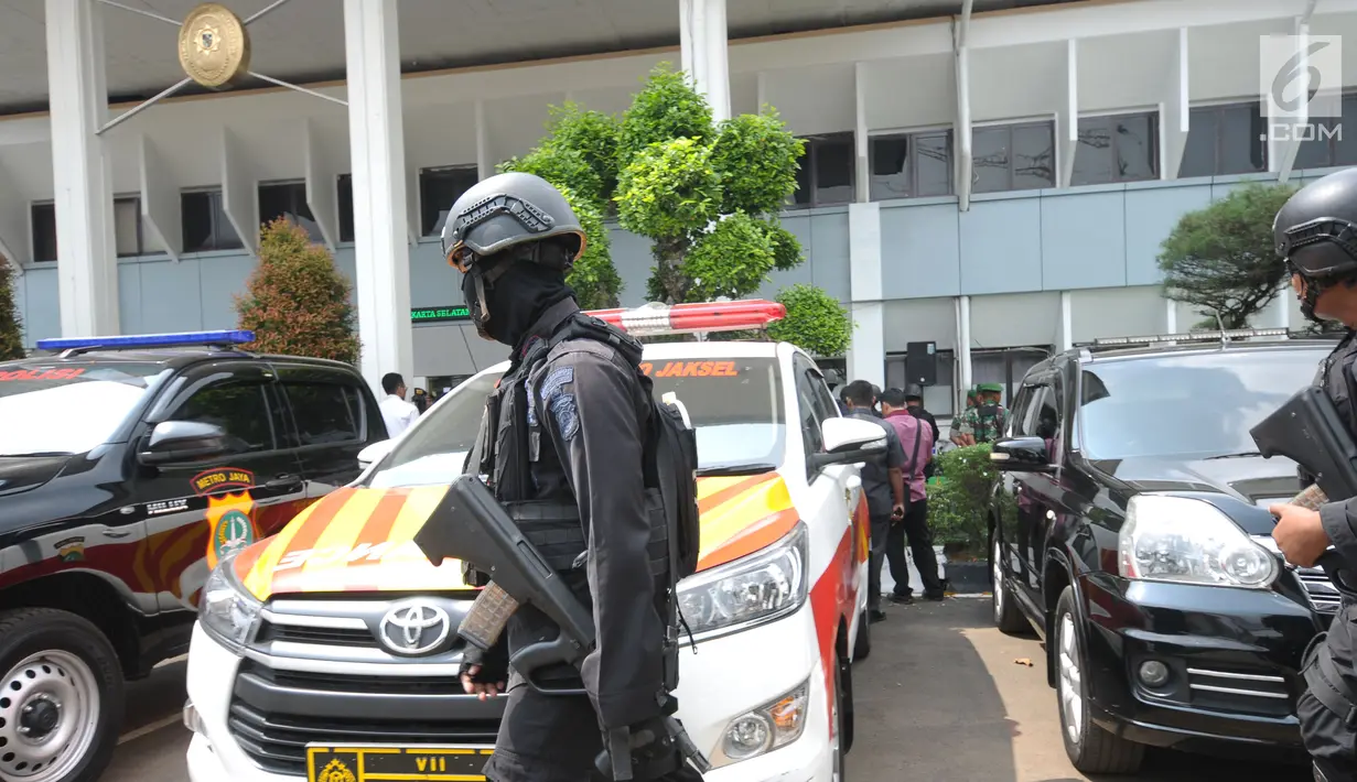 Personel Brimob berpatroli di sekitar halaman depan PN Jakarta Selatan saat sidang pembacaan tuntutan terhadap terdakwa sejumlah kasus tindak pidana terorisme, Aman Abdurrahman, Jumat (18/5). (Liputan6.com/Helmi Fithriansyah)