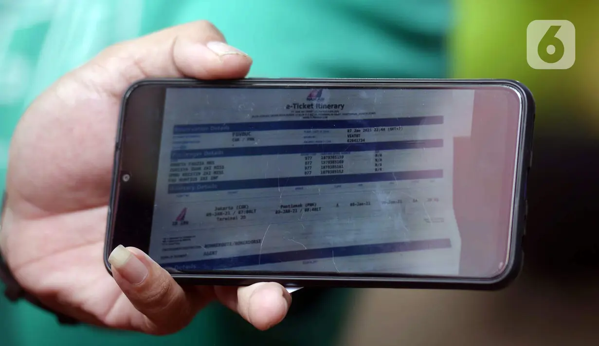 Layar handphone memperlihatkan gambar tiket pesawat di Posko Ante Mortem-DVI RS Polri Jakarta, Selasa (12/1/2021). Hingga saat ini, tim DVI masih mengumpulkan sampel DNA penumpang pesawat Sriwijaya Air SJ 182 yang jatuh di perairan Kepualauan Seribu. (merdeka.com/Imam Buhori)