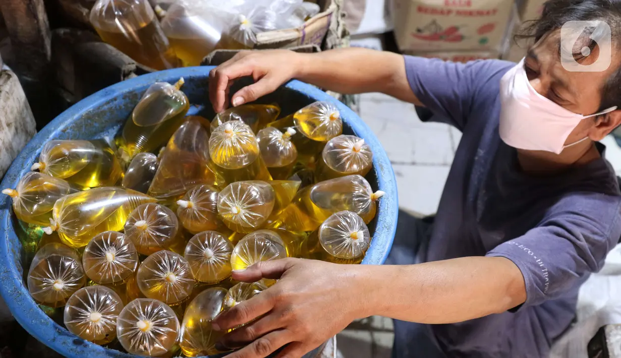 Pedagang tengah menata minyak curah yang dijual di pasar di Kota Tangerang, Banten, Kamis (25/11/2021). Pemerintah melarang peredaran minyak goreng curah ke pasar per tanggal 1 Januari 2022. (Liputan6.com/Angga Yuniar)